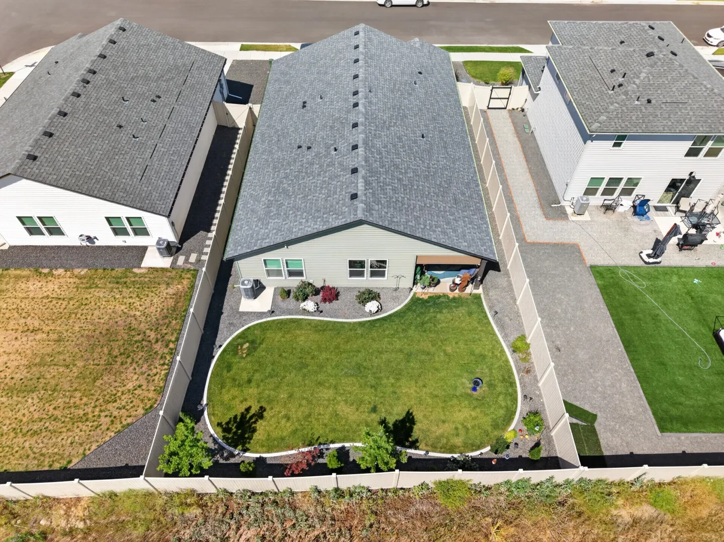 Aerial rooftop view of backyard with curved lawn