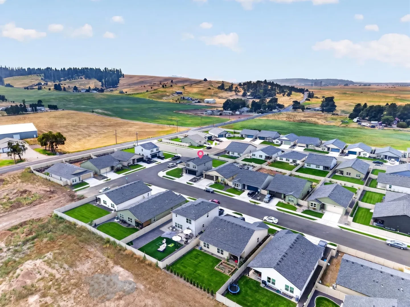 Aerial view of residential subdivision with farmland backdrop